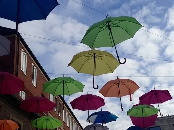 Bunte Regenschirme schweben über einer Gasse