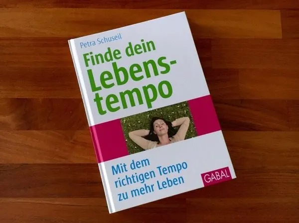 Buch „Finde dein Lebenstempo“ von Petra Schuseil auf einem Holztisch